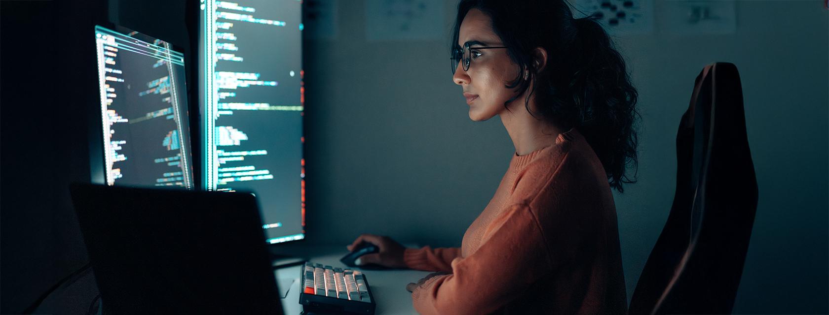 Young woman focusing on her multiple computer screens.