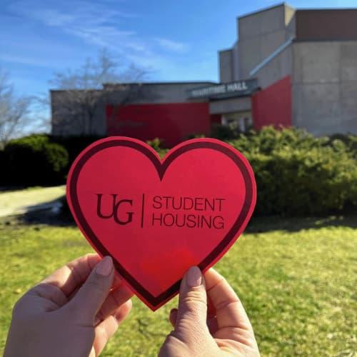 A heart shaped card with student housing written on it and mountain hall residence is in the background