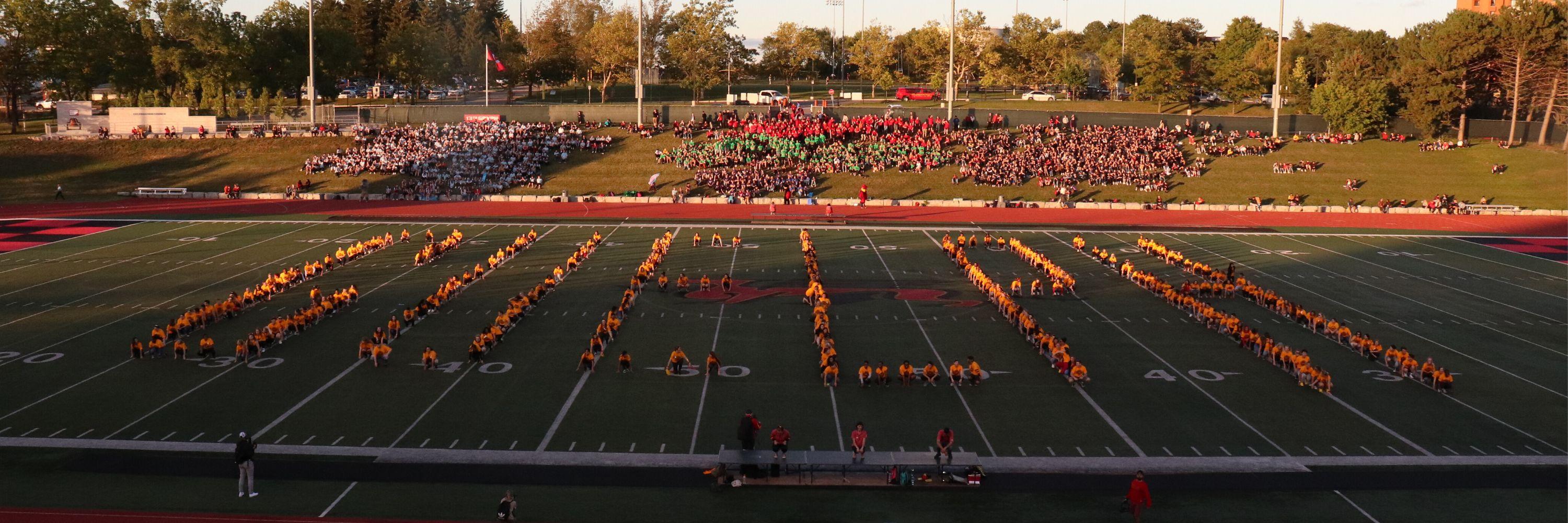 Students on football field spelling "Guelph"