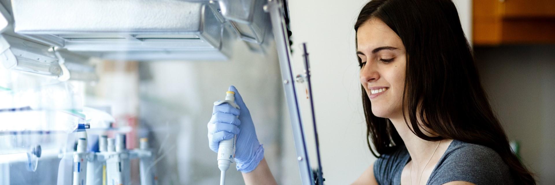 person working in lab, holding syringe