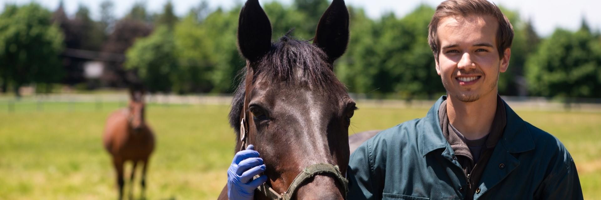 Person smiles beside a horse.