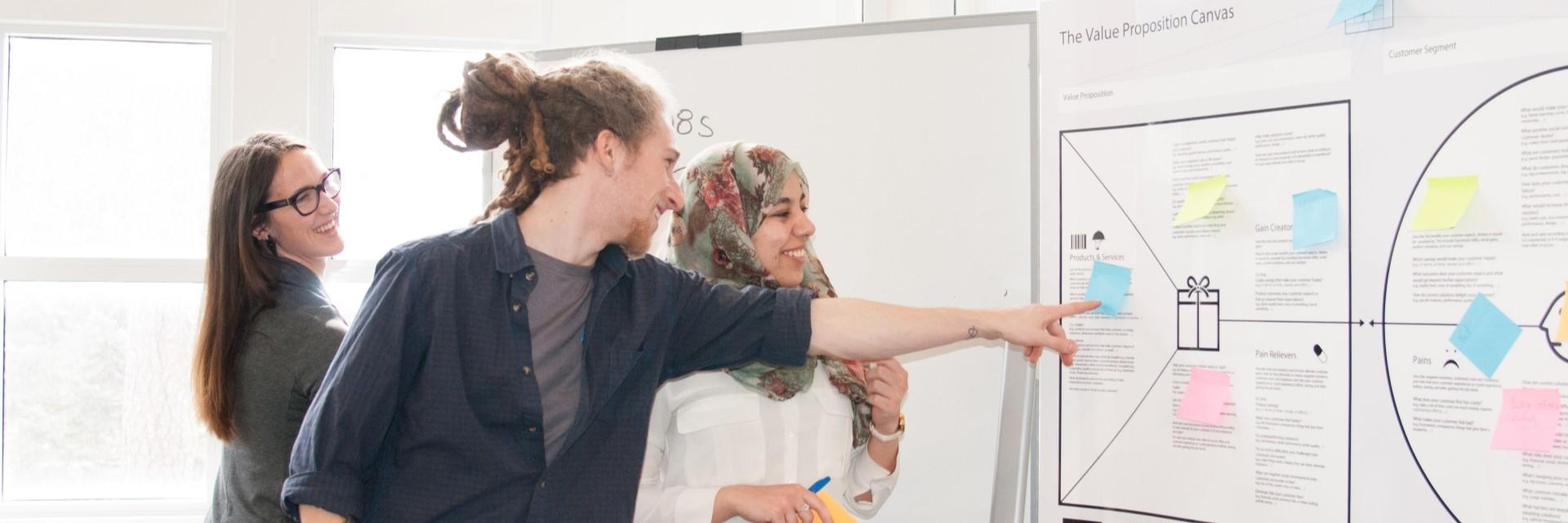 three people looking at business strategy board