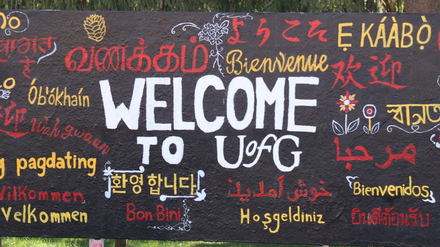 sign reading "Welcome to U of G" with "welcome" written in many languages
