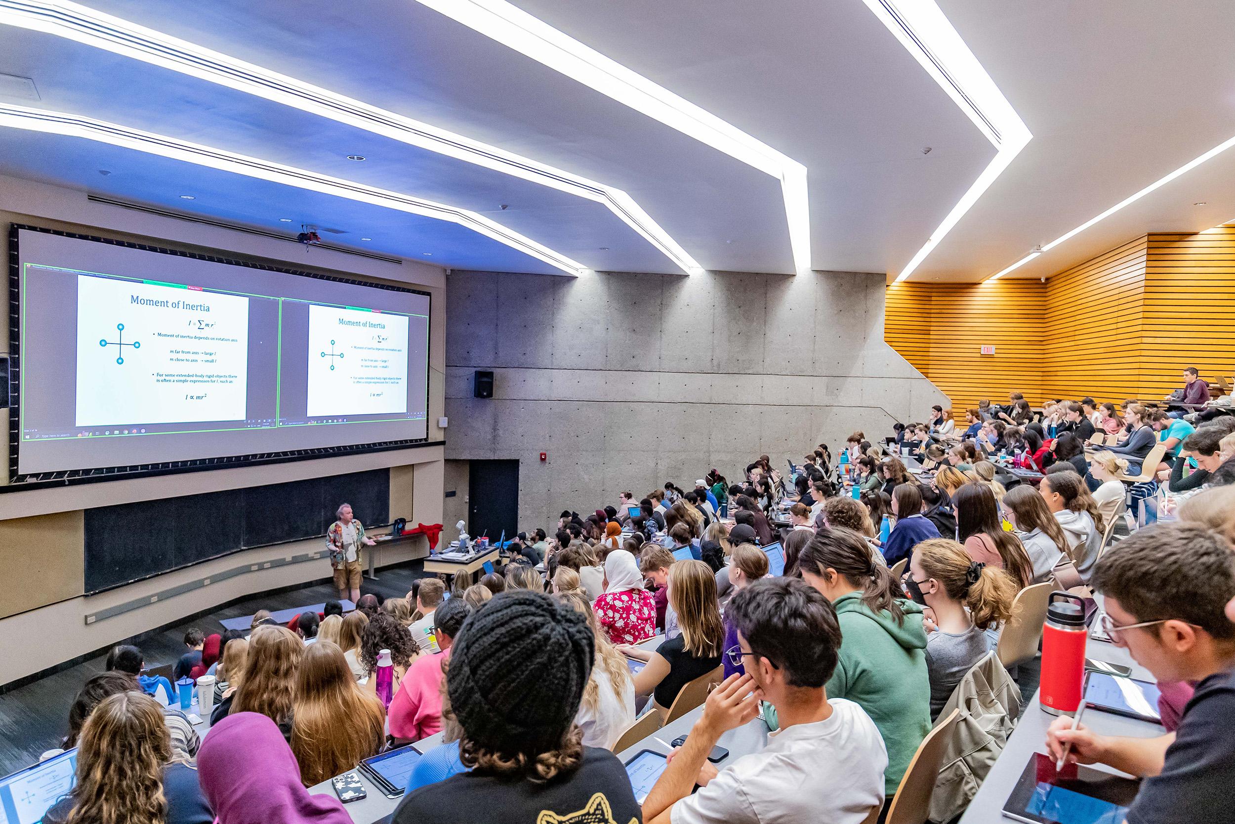 Image of prof speaking to large group of undergrad students