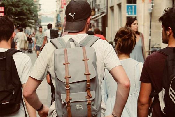 students with backpacks on their packs walking outside in foreign country