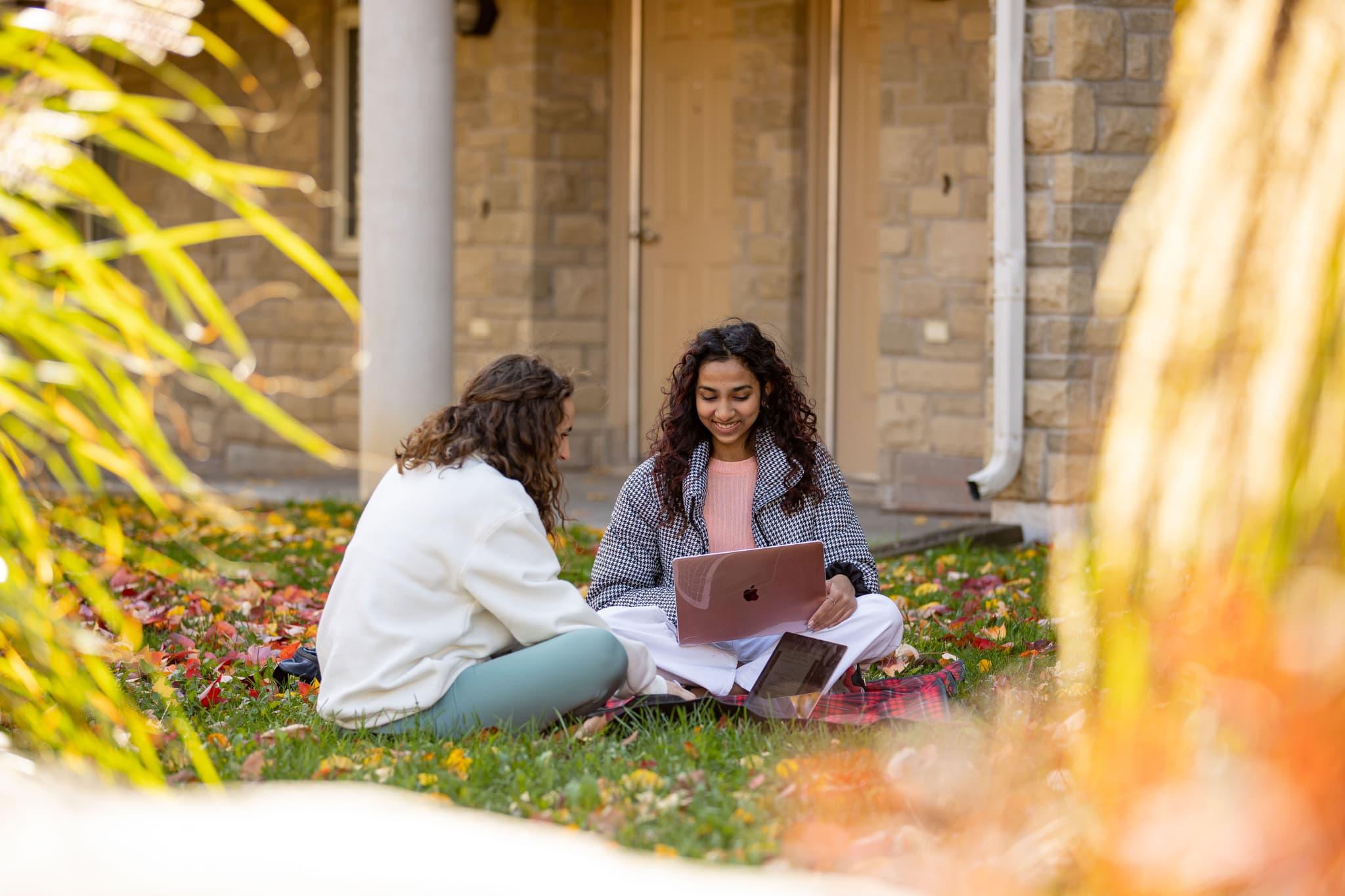 Students sitting and chatting outside the east residence