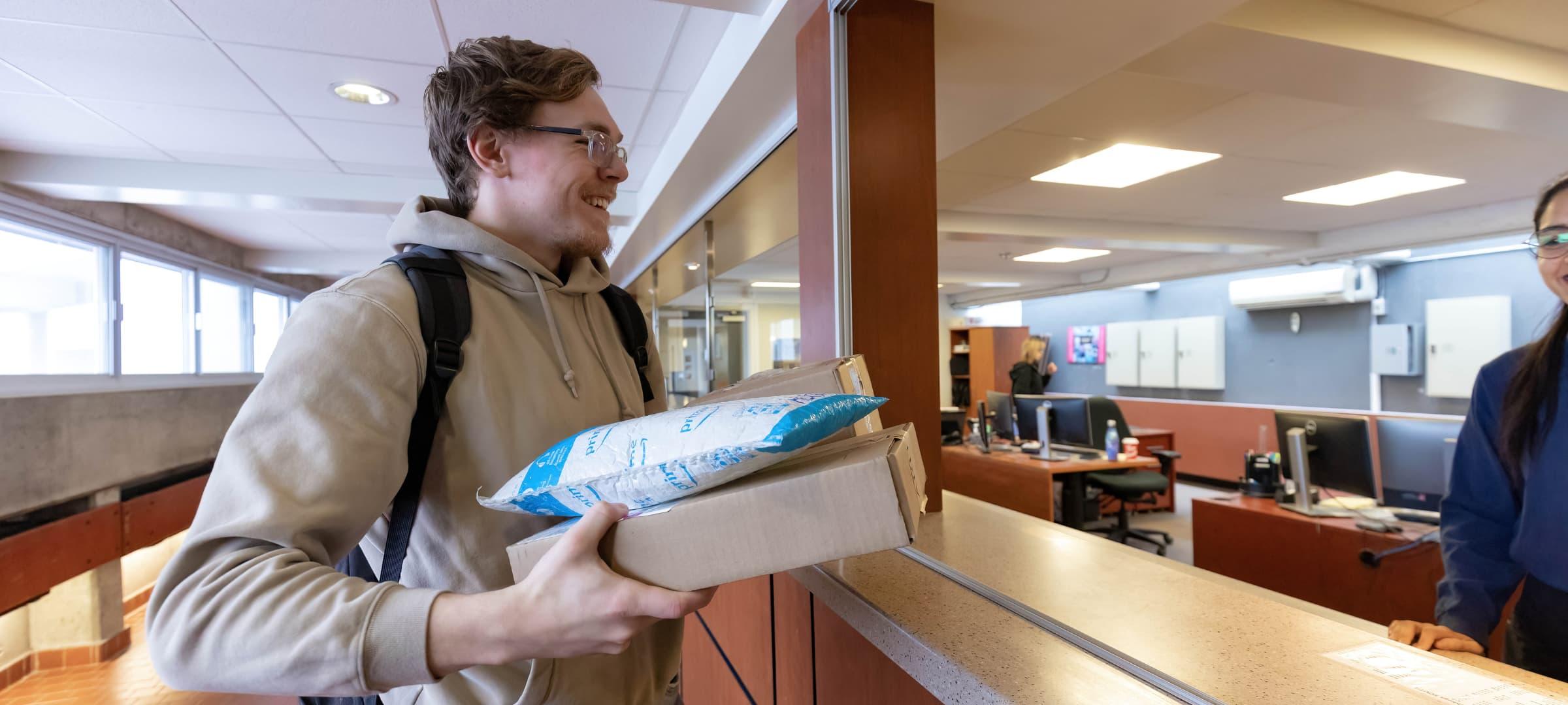 Student receiving package from residence desk staff