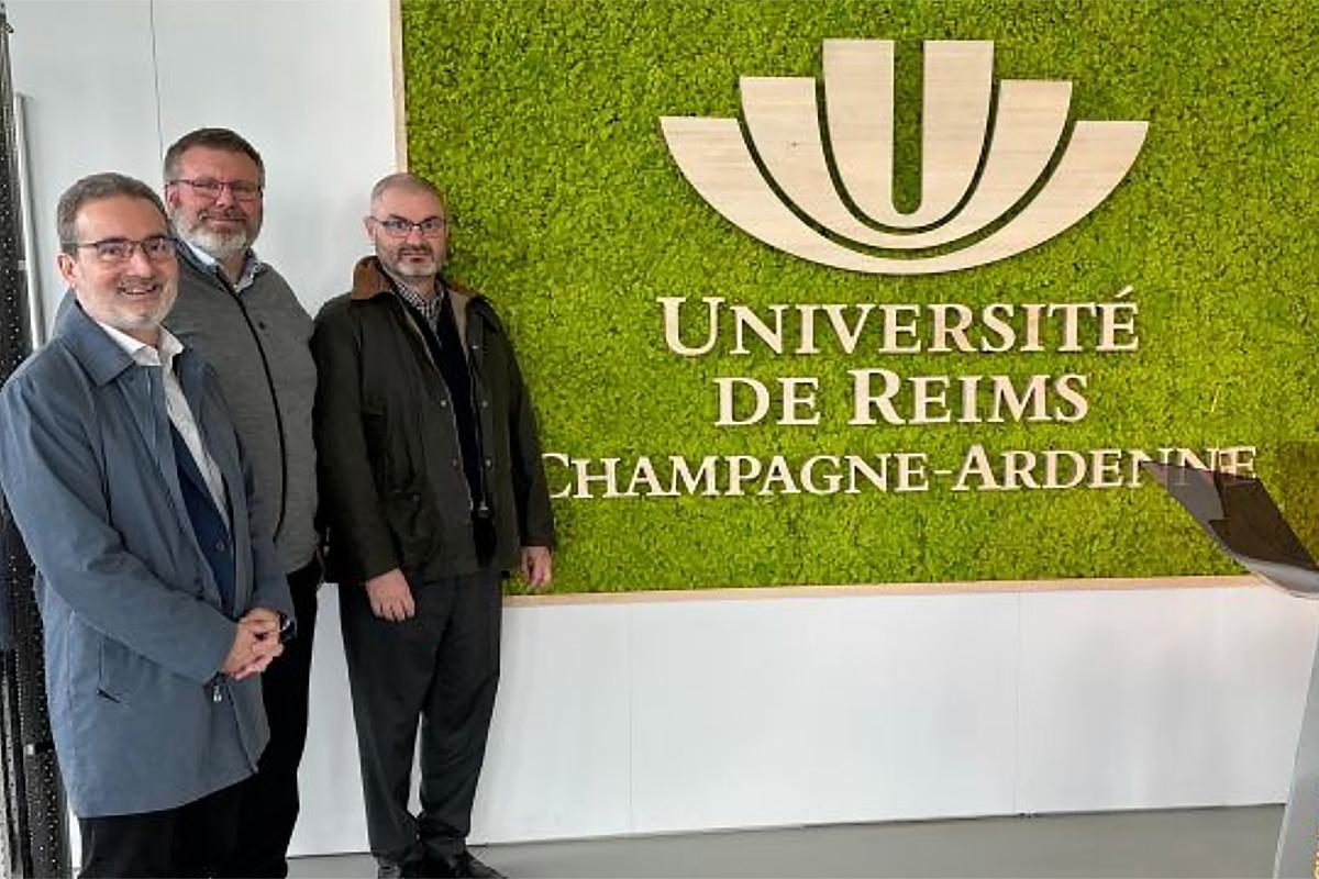 Vice-President of Research standing in front of sign for the University of Reims Champagne-Ardenne sign