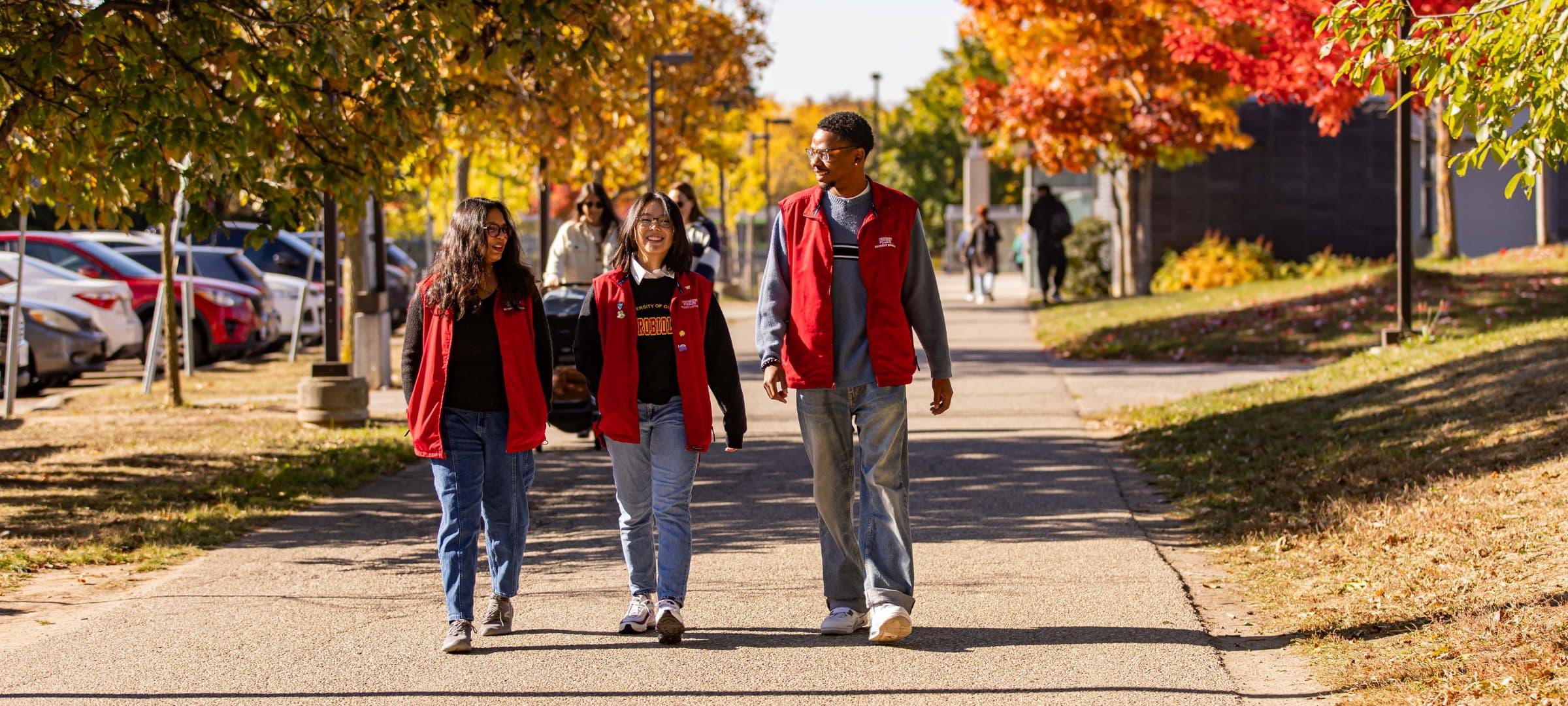 Three students in the RLS vest outside Prairie Hall