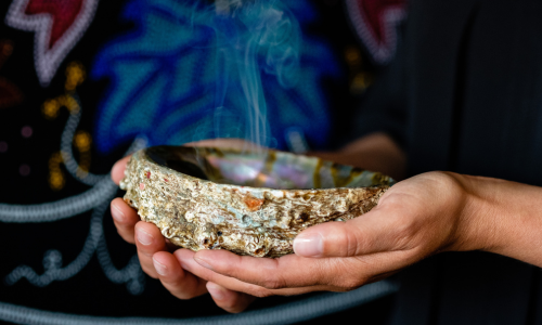 Hands holding a bowl with smoke
