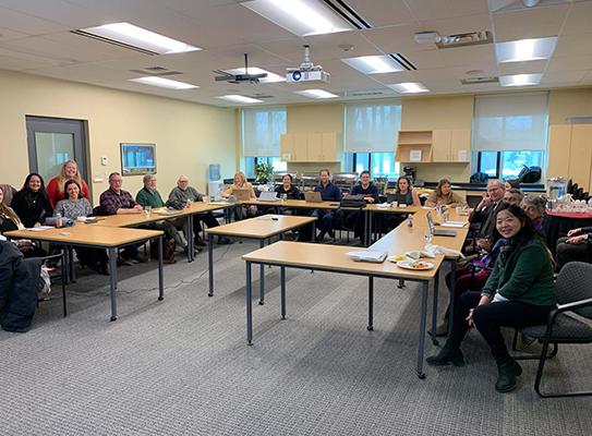 A meeting with many people sitting around a room