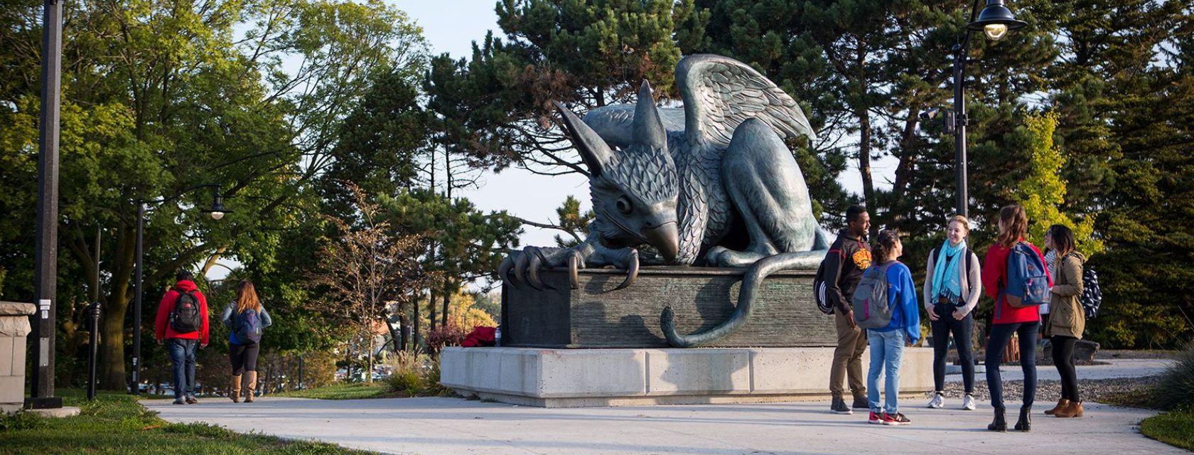 Students gather around the Gryphon statue on the U of G campus.