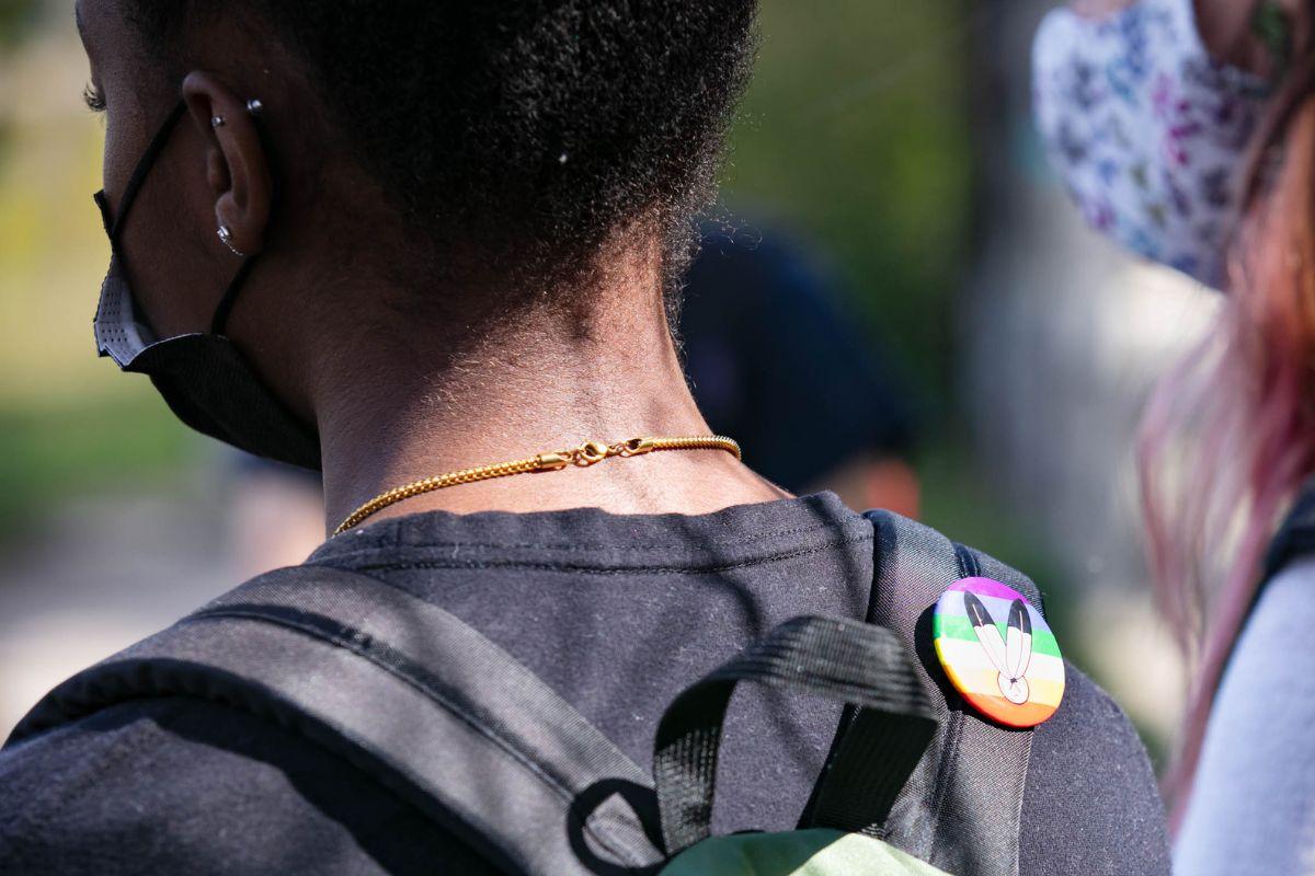 Student with a pride and 2 spirit pin on their backpack