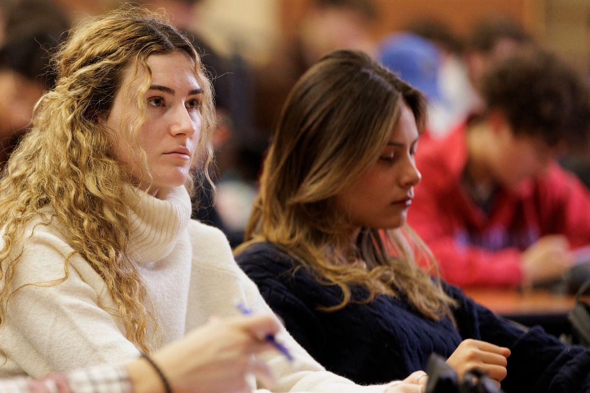 Students sitting in a lecture hall listening attentively.