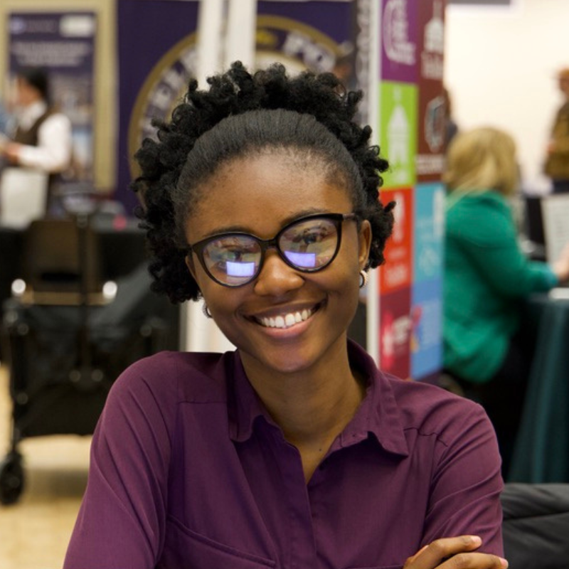 An employer smiles at the camera at a job fair.