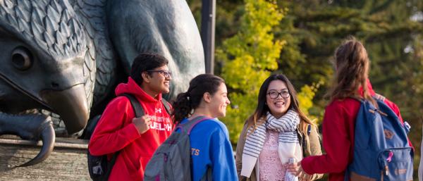 students standing in front of the Gryphon statue