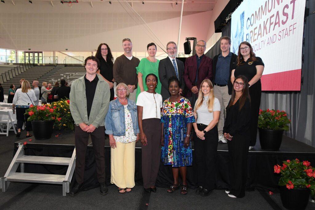 Exemplary Staff Award winners standing on stage with President Rene Van Acker