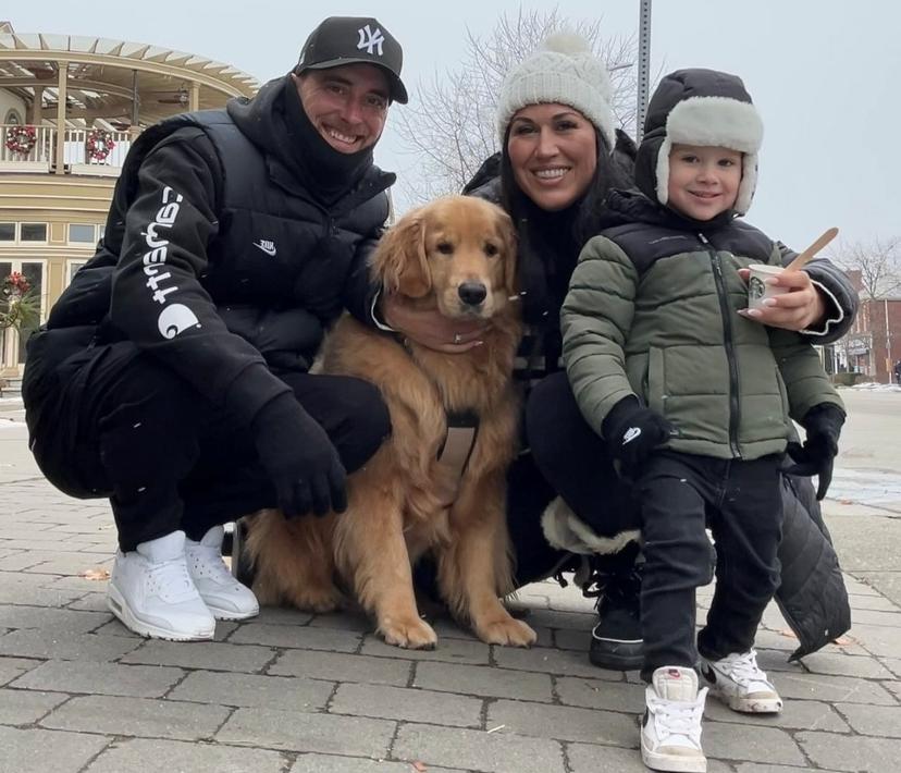 Three people and a golden retriever dog