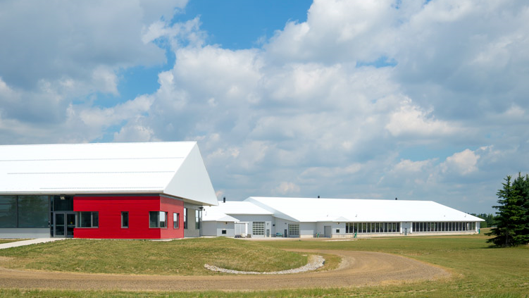 From outside, the Ontario Dairy Research Centre is a bright red building with a long white barn behind it