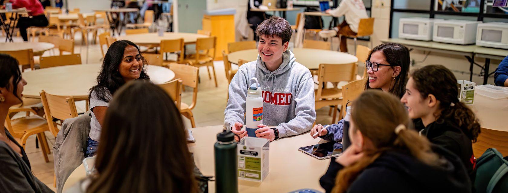 A group of students gathered at a table in deep conversation
